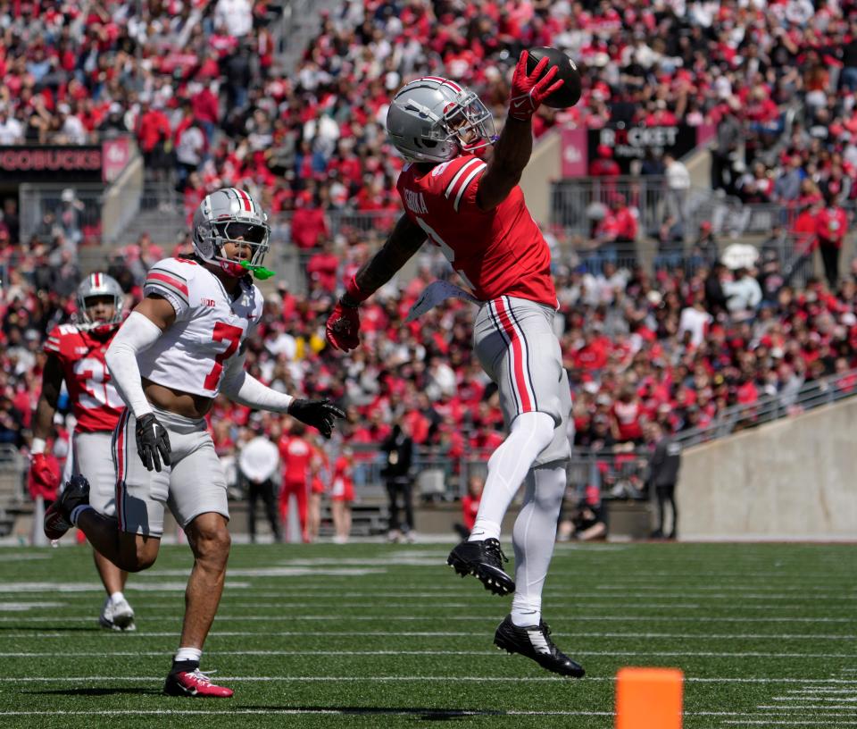 April 13, 2024; Columbus, Ohio, USA; 
Ohio State Buckeyes wide receiver Emeka Egbuka (2) catches a pass for the scarlet team while defended by cornerback Jordan Hancock (7) of the grey team during the first half of the LifeSports Spring Game at Ohio Stadium on Saturday.