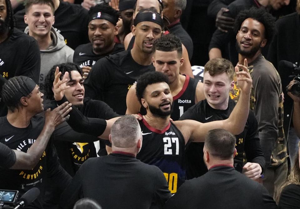 Denver Nuggets guard Jamal Murray (27) celebrates with teammates after his winning shot.