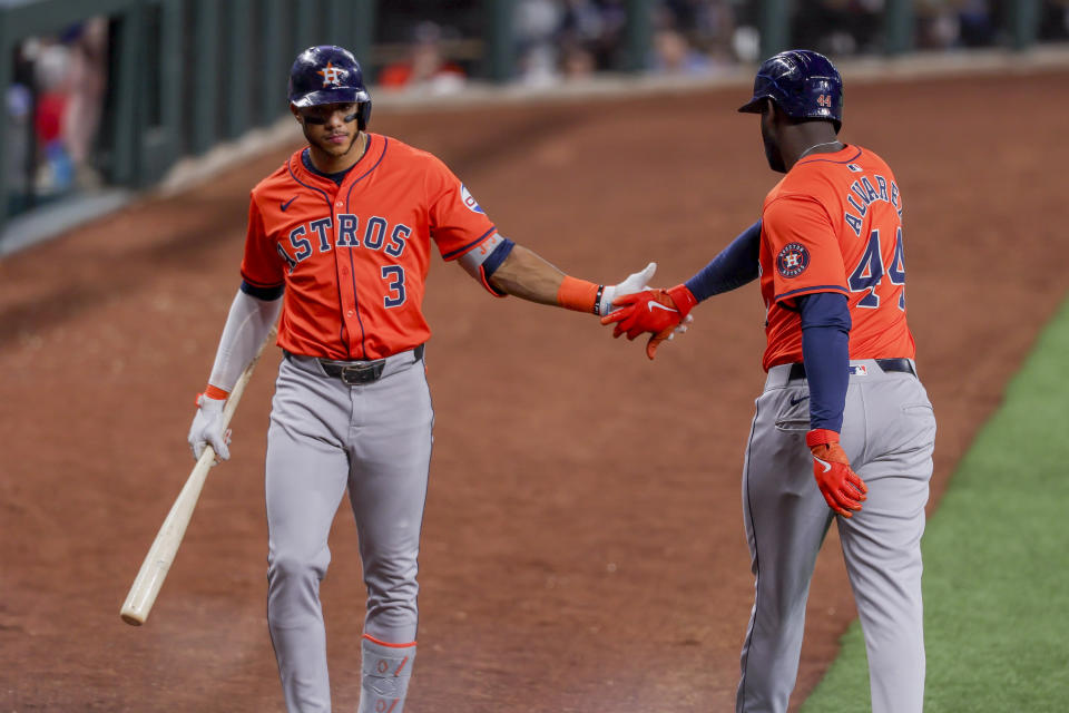 Houston Astros' Jeremy Peña (3) and teammate Yordan Alvarez (44) celebrate after Alvarez scored on an Alex Bregman single during the first inning of a baseball game against the Texas Rangers, Monday, April 8, 2024, in Arlington, Texas. (AP Photo/Gareth Patterson)