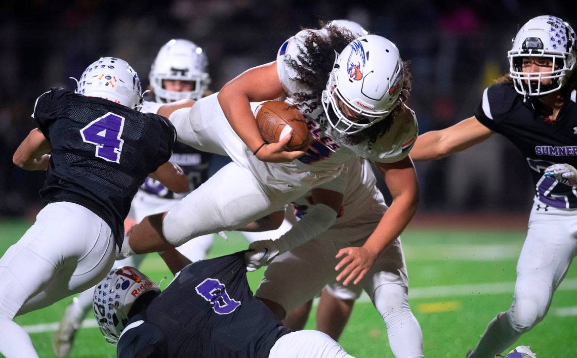 Graham-Kapowsin running back Michael Toa flies into the end zone past Sumner defenders Dylan Coffey (4) and Caden Evans for a touchdown run during Friday night’s 4A football state quarterfinal game at Sunset Chev Stadium in Sumner, Washington, Nov. 18, 2022. Graham-Kapowsin won the game, 28-21. Tony Overman/toverman@theolympian.com