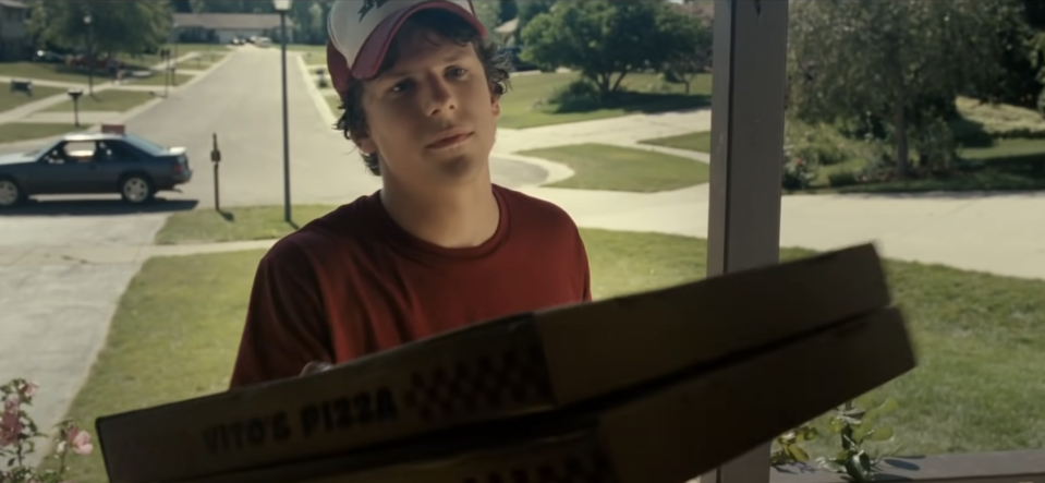 A pizza delivery boy delivering a pizza