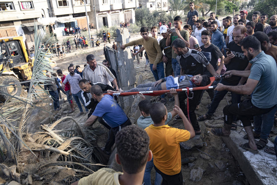 Palestinians carry a person wounded in Israeli airstrikes in Khan Younis, Gaza Strip, Monday, Oct. 16, 2023. (AP Photo/Fatima Shbair)