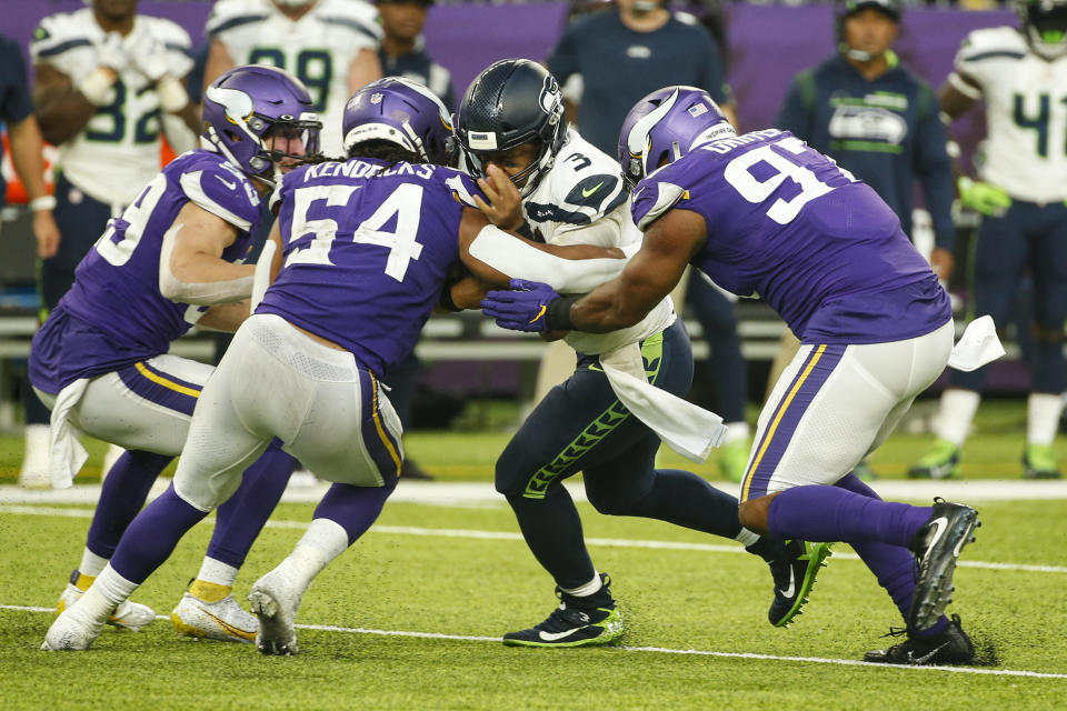Seattle Seahawks quarterback Russell Wilson (3) is tackled by Minnesota Vikings middle linebacker Eric Kendricks (54) and defensive end Everson Griffen (97) in the second half of an NFL football game in Minneapolis, Sunday, Sept. 26, 2021. (AP Photo/Bruce Kluckhohn)