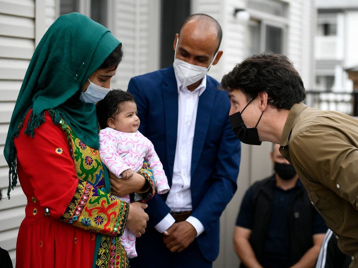 Prime Minister Justin Trudeau gets a smile from two-month-old Hawa Rahimi as he meets her parents in Ottawa, on Saturday, Oct. 9, 2021. This family resettled in the Ottawa area last summer after fleeing Afghanistan. One advocate who helps Afghans says this community has been largely forgotten in recent months, as Ottawans turned their focus to helping Ukrainians fleeing war.  (Justin Tang/The Canadian Press - image credit)