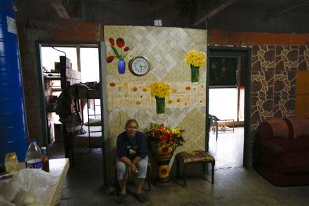 Adriana Gutierrez sits in the living of her 24th floor apartment inside the "Tower of David" skyscraper in Caracas February 3, 2014. REUTERS/Jorge Silva