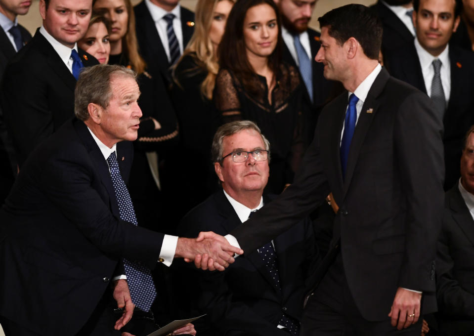 Speaker of the United States House of Representatives Paul Ryan (R-WI) (R) shakes hands with former US President George W. Bush as the late former President George H.W. Bush lies in state inside the Rotunda of the US Capitol, December 3, 2018 in Washington, DC. (Photo: Brendan Smialowski/Pool via Reuters)