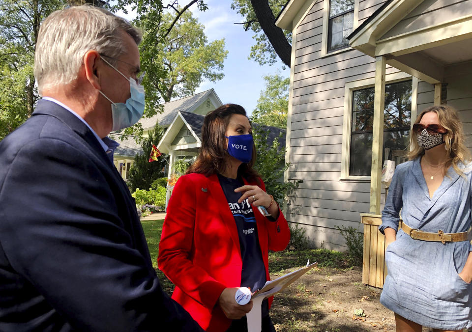 ADDS NAME OF SUBJECT AT RIGHT - Michigan Gov. Gretchen Whitmer, center, and legislative candidate Dan O'Neil, left, greet Rachel White in Traverse City, Mich., Friday, Oct. 9, 2020. Whitmer visited the area the day after police announced a foiled plot to kidnap the governor. (AP Photo/John Flesher)