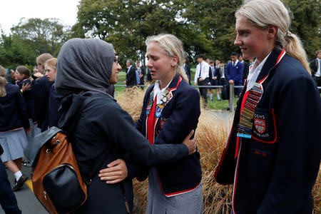 High school students embrace as they give hugs to Muslims waiting for news of their relatives at a community centre, following Friday's shooting in Christchurch, New Zealand March 18, 2019. REUTERS/Jorge Silva