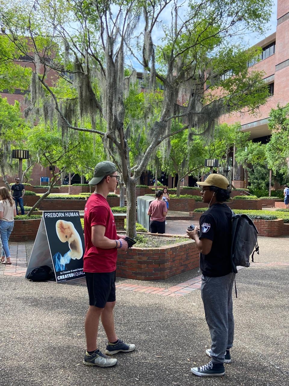 Students stand in UF's Turlington Plaza near the anti-abortion displays on March 10, 2023.