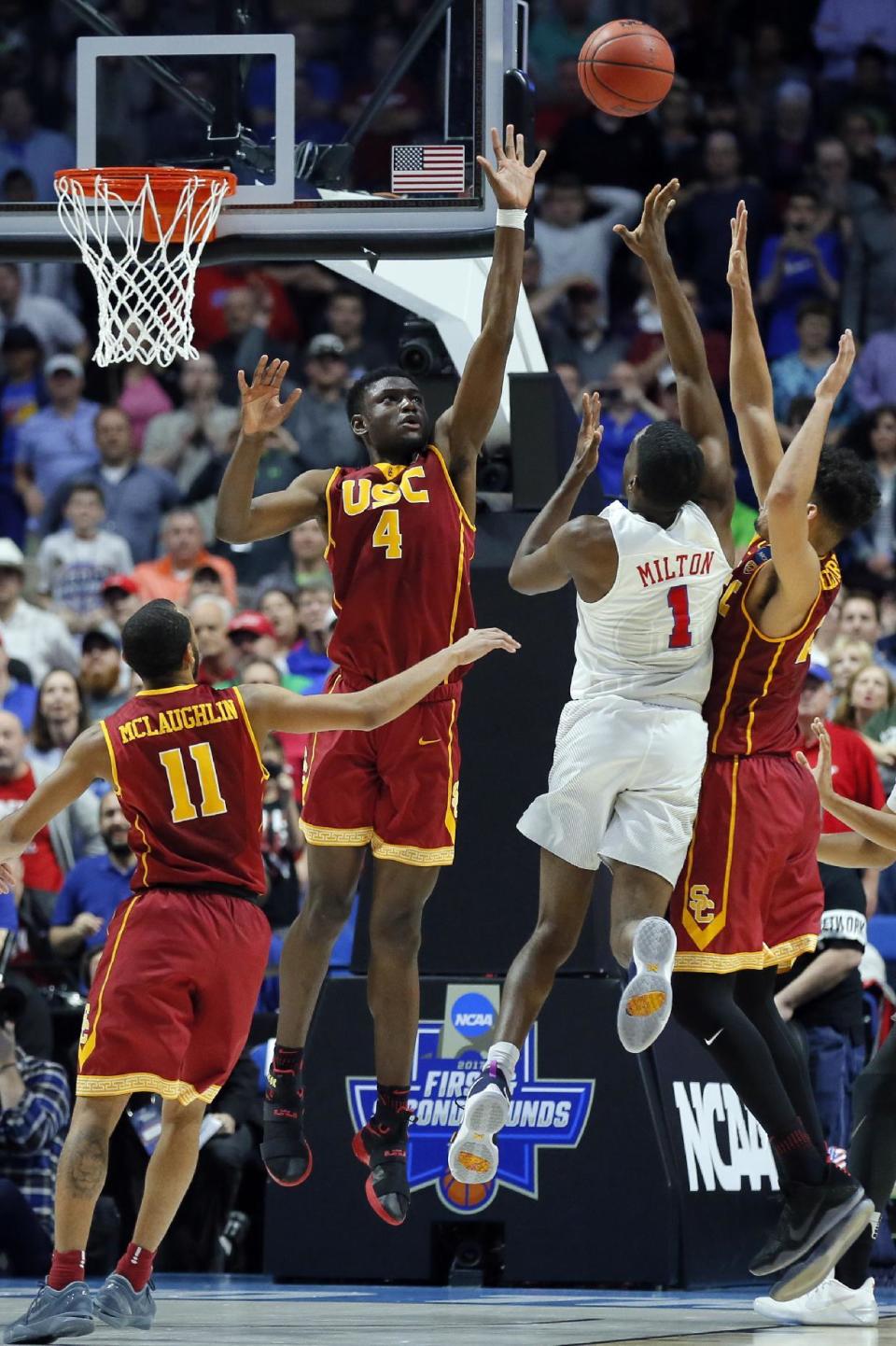 SMU guard Shake Milton (1) throws up an unsuccessful last second shot as Southern California's Jordan McLaughlin (11), Chimezie Metu (4) and Bennie Boatwright, right, defend in the second half of a first-round game in the men's NCAA college basketball tournament in Tulsa, Okla., Friday March 17, 2017. Southern California won 66-65. (AP Photo/Tony Gutierrez)