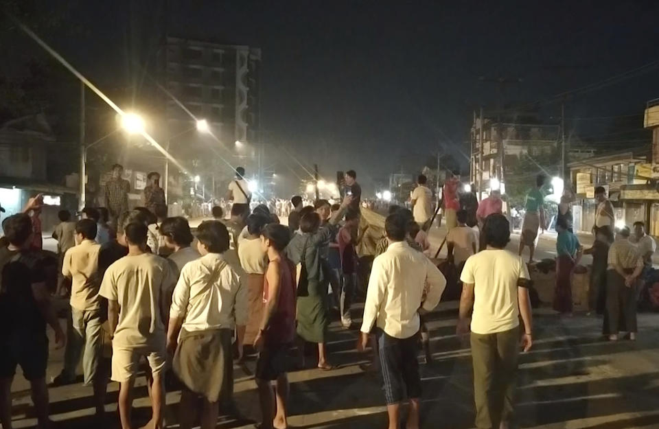 In this image taken from video, people stand outside their homes and gather together on a road in Insein township in Yangon, Myanmar, Monday, March 8, 2021. Demonstrators in Myanmar’s biggest city came out Monday night for their first mass protests in defiance of an 8 p.m. curfew, seeking to show support for an estimated 200 students trapped by security forces in a small area of one neighborhood. (AP Photo)