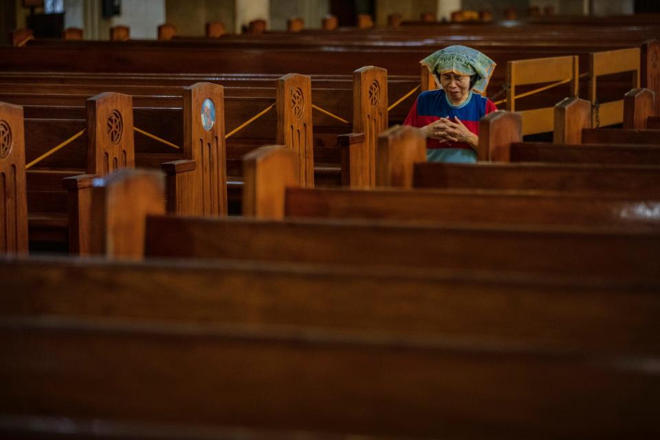 A woman prays on her knees in the aisle of an empty church as authorities ban religious gatherings amid the threat of the coronavirus on March 22, 2020 in Manila, Philippines.