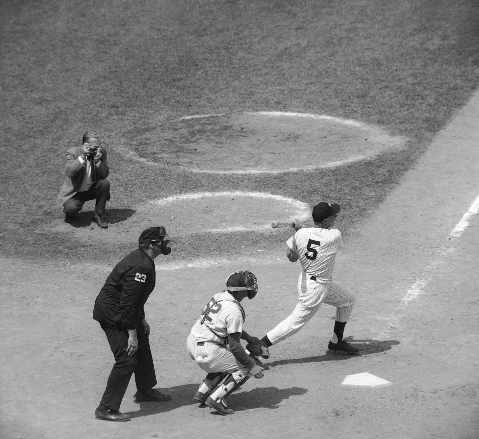 FILE - Joe DiMaggio (5), former New York Yankees baseball great, hits a single in the New York Mets' Old Timers' Game at Shea Stadium in New York on July 31, 1971, as Joe Pignatano (52), a former Brooklyn Dodgers player, catches and umpire is Lee Weyer, bottom left, look on. Pignatano, who made his major league debut with the Dodgers in 1957 and later was a coach for the New York Mets, died Monday, May 23, 2022, in Naples, Fla. (AP Photo/John Rooney, File)