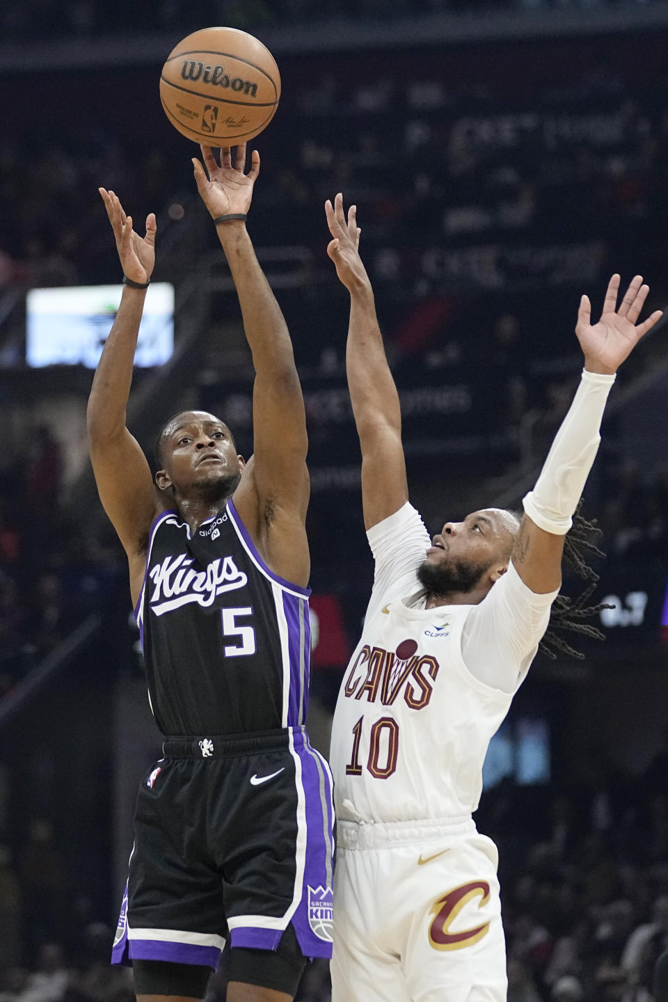 Sacramento Kings guard De'Aaron Fox (5) shoots next to Cleveland Cavaliers guard Darius Garland (10) in the first half of an NBA basketball game, Monday, Feb. 5, 2024, in Cleveland. (AP Photo/Sue Ogrocki)