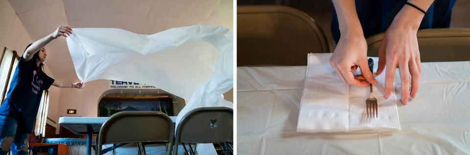 LEFT: Emma Aldridge, 14, lays a tablecloth on a table before the start of the annual Hunter's Stew dinner, held by the Herman Historical Society, to bring the community together and help save the frail, historic Herman Hall in Michigan's Upper Peninsula on Saturday, Nov. 18, 2023. RIGHT: Aldridge places silverware the table. Everyone got silverware and china. No plastic is ever used for the dinners.
