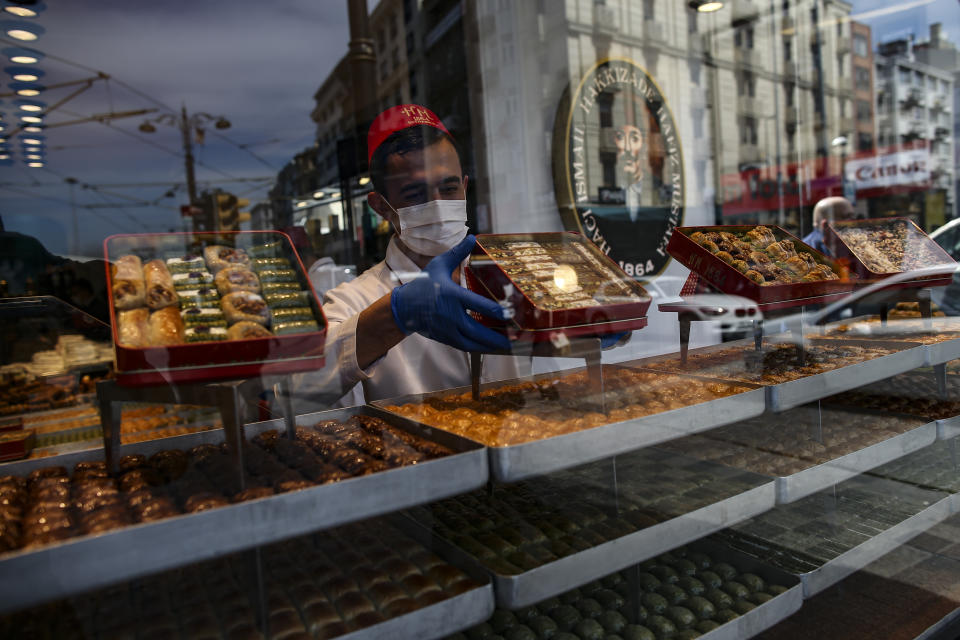 A worker prepares traditional Turkish sweets in a restaurant, in Istanbul, Tuesday, April 13, 2021. As Muslims around the world began marking Ramadan Tuesday, in mostly-Muslim Turkey, the month of fasting kicked off with some restrictions amid record levels of COVID-19 infections. (AP Photo/Emrah Gurel)