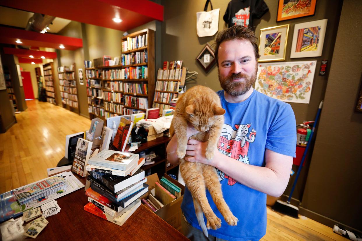 Josh Arnett, owner of Bookmarx bookstore in downtown Springfield, and store cat Googey on Thursday, April 27, 2023.