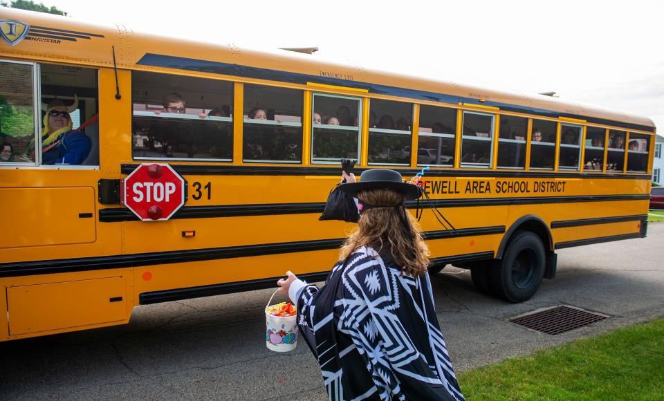 Hopewell mom Erin Mulder heads to the Hopewell bus, driven by Rose George, to give candy treats to students on May 25, 2022.
