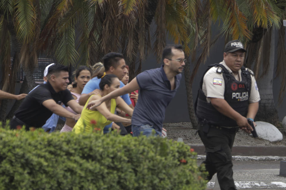 La policía evacúa a personal del canal TC Televisión después de que un grupo armado y encapuchado irrumpiera en plena transmisión en directo, en Guayaquil, Ecuador, el martes 9 de enero de 2024. El país ha registrado una secuencia de ataques violentos desde que el gobierno decretara el estado de excepción el lunes 8 de enero, tras la presunta fuga de un peligroso cabecilla de una banda criminal que opera en el país. (AP Foto/César Muñoz)