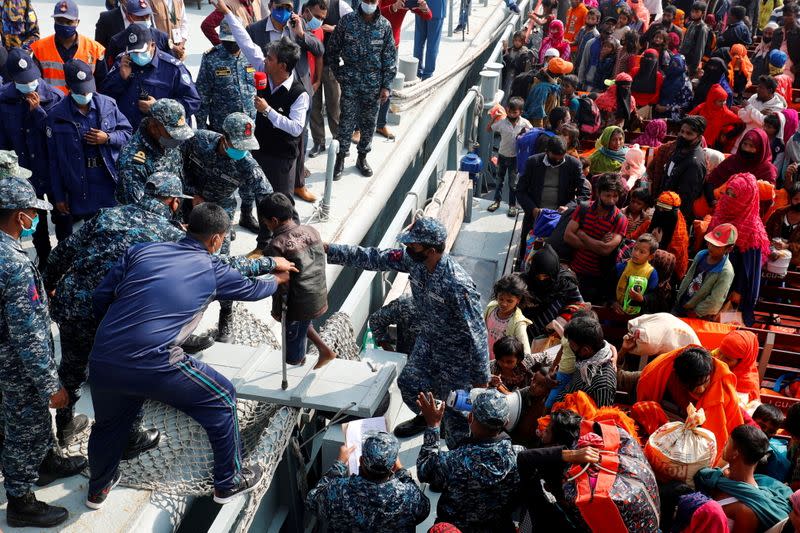 FILE PHOTO: Bangladesh Navy personnel help a disabled Rohingya refugee child to get off from a navy vessel as they arrive at the Bhasan Char island in Noakhali district