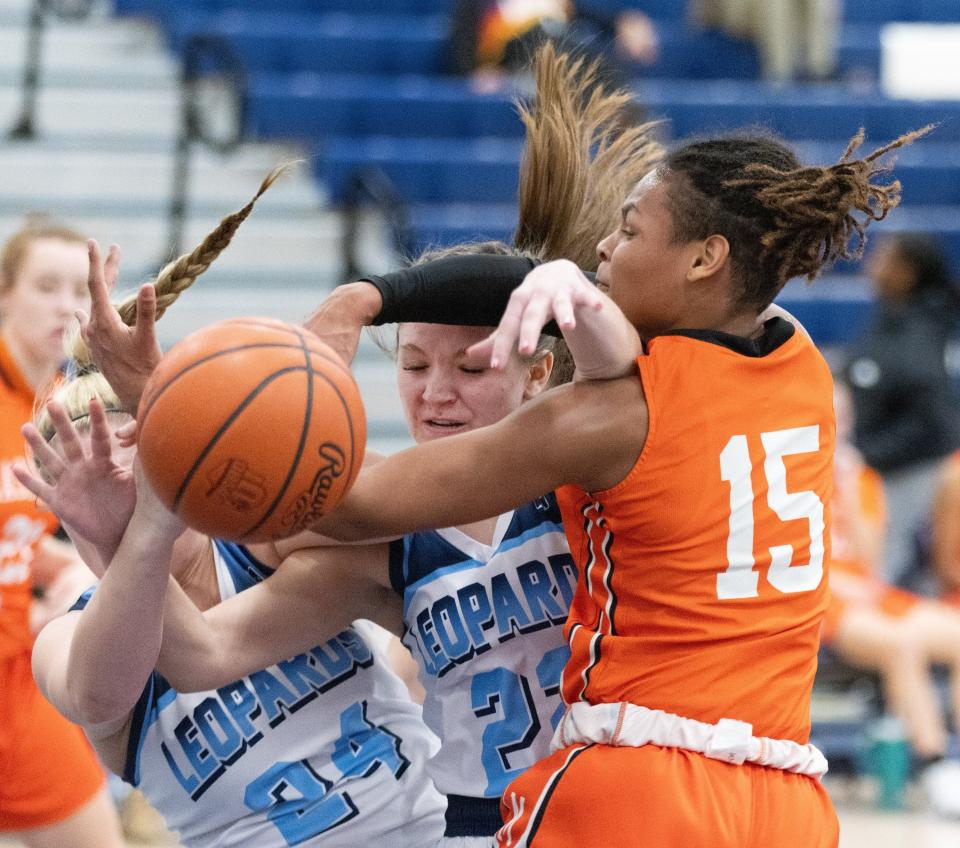 Massillon’s La Tia Moore is called for fouling going for a rebound with Louisville’s Brooke Haren (24) and Alexis Wasara on Thursday, Dec. 14, 2023.