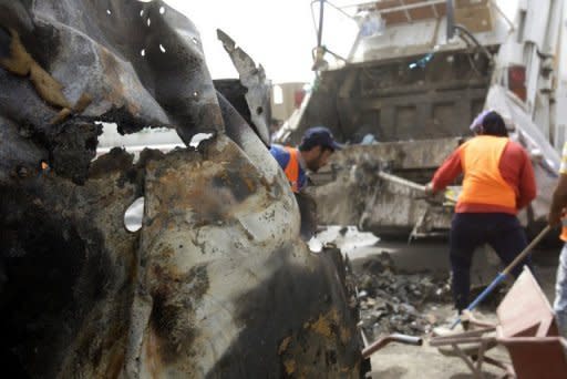 Iraqis remove debris after a blast in central Baghdad as a wave of apparently coordinated bombing and shooting attacks in six different provinces across Iraq killed at least 38 people and wounded more than 150, security officials said