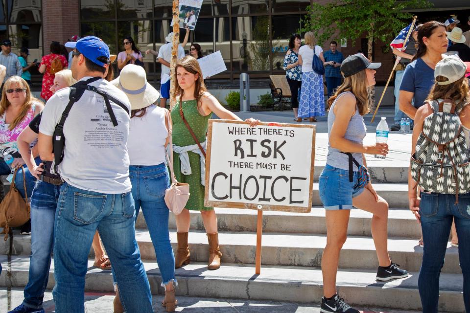 Emily Wahl, center, and more than 100 other people gather at City Hall to protest Mayor Lauren McLean's order mandating people to wear face coverings in Boise, Idaho, Friday, July 3, 2020.