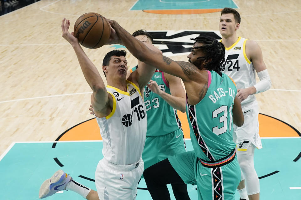 Utah Jazz forward Simone Fontecchio (16) is fouled by San Antonio Spurs forward Keita Bates-Diop as he drives to the basket during the second half of an NBA basketball game in San Antonio, Wednesday, March 29, 2023. (AP Photo/Eric Gay)