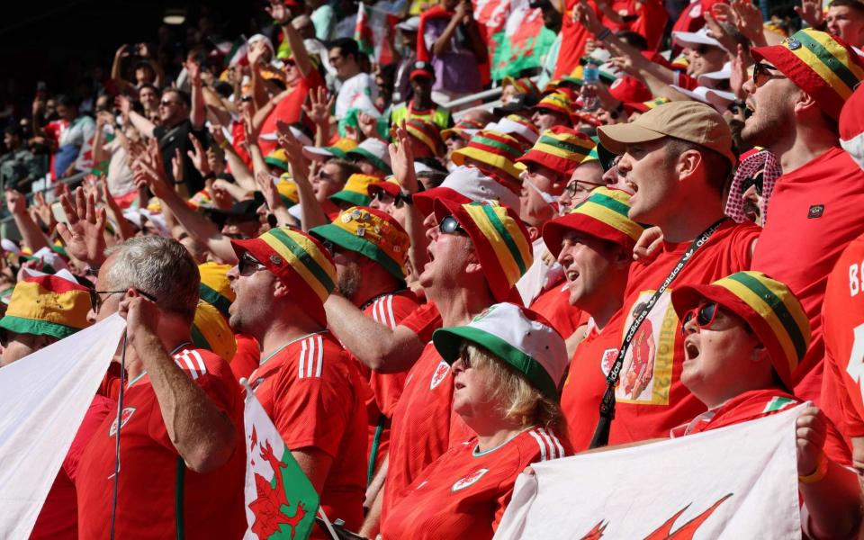 Wales supporters sing the national anthem at the start of the Qatar 2022 World Cup Group B football match between Wales and Iran at the Ahmad Bin Ali Stadium - AFP
