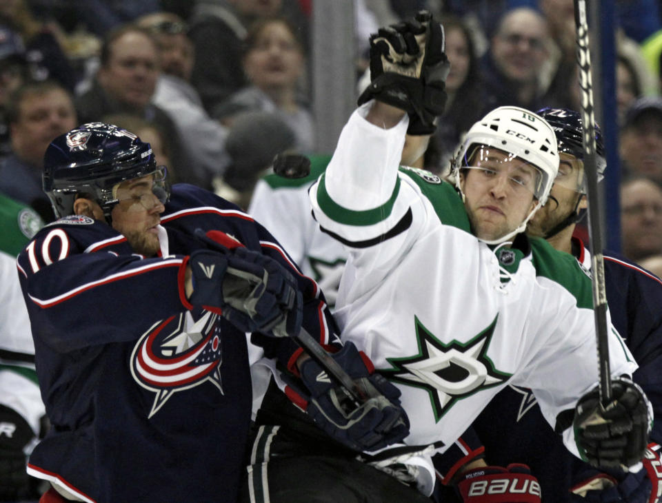 Columbus Blue Jackets' Marian Gaborik, left, of Slovakia, and Dallas Stars' Chris Mueller work for the puck in the first period of an NHL hockey game in Columbus, Ohio, Tuesday, March 4, 2014. (AP Photo/Paul Vernon)