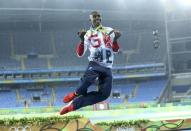 2016 Rio Olympics - Athletics - Final - Men's 5000m Final - Olympic Stadium - Rio de Janeiro, Brazil - 20/08/2016. Gold winner Mohamed Farah (GBR) of Britain celebrates and dances in the rain. REUTERS/Stoyan Nenov