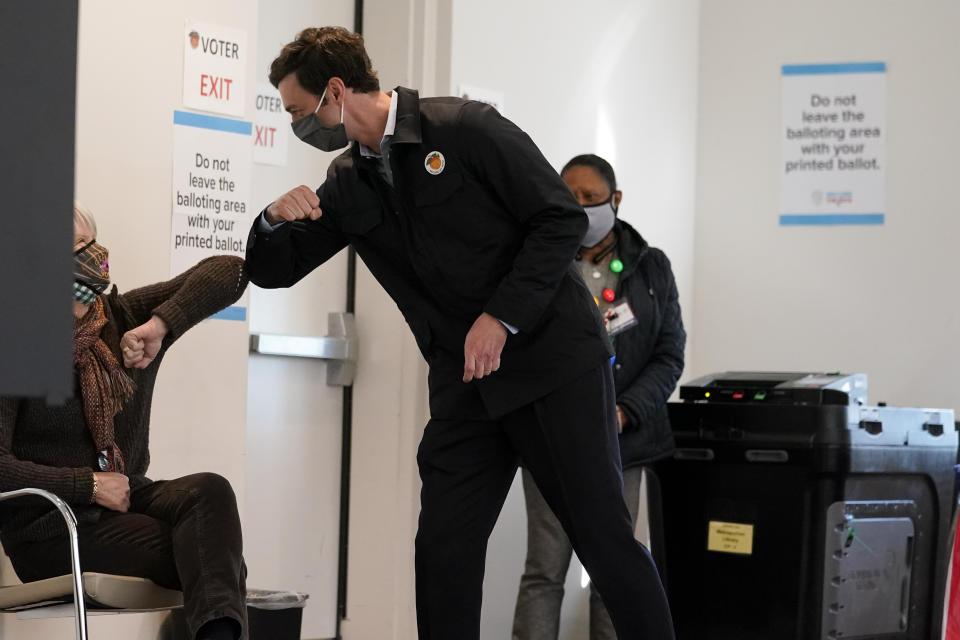 Democratic nominee for U.S. Senate from Georgia Jon Ossoff greets a poll worker after voting early in Atlanta on Tuesday, Dec. 22, 2020. For the second time in three years, Jon Ossoff is campaigning in overtime. The question is whether the 33-year-old Democrat can deliver a win in a crucial Jan. 5 runoff with Republican Sen. David Perdue. (AP Photo/John Bazemore)