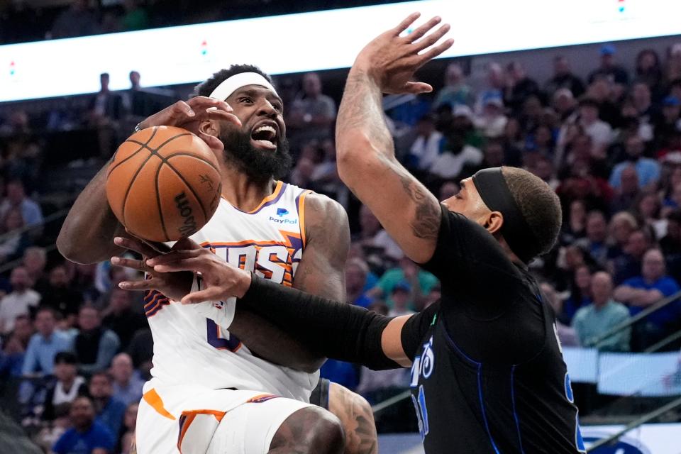 Phoenix Suns forward Royce O'Neale, left, loses control of the ball on a drive to the basket as Dallas Mavericks' Daniel Gafford, right, defends in the first half of an NBA basketball game in Dallas on Thursday, Feb. 22, 2024.