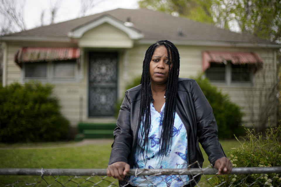 Karen Pitchford-Knox stands in front of her home Monday, April 19, 2021, in Kansas City, Kan. Pitchford-Knox found out from a state senator that her home was put up for sale by Wyandotte County in January when she fell behind on her property tax payments after loosing her job during the pandemic. (AP Photo/Charlie Riedel)