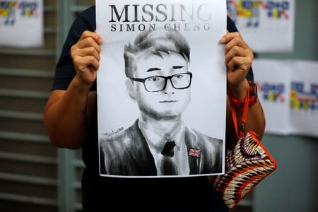 A woman holds a poster of Simon Cheng, a staff member at the consulate who went missing on August 9 after visiting the neighbouring mainland city of Shenzhen, during a protest outside the British Consulate-general office in Hong Kong