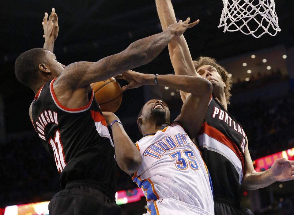 Oklahoma City Thunder forward Kevin Durant (35) shoots between Portland Trail Blazers forward Thomas Robinson, left, and center Robin Lopez, right, in the fourth quarter of an NBA basketball game in Oklahoma City, Tuesday, Jan. 21, 2014. Oklahoma City won 105-97. (AP Photo/Sue Ogrocki)