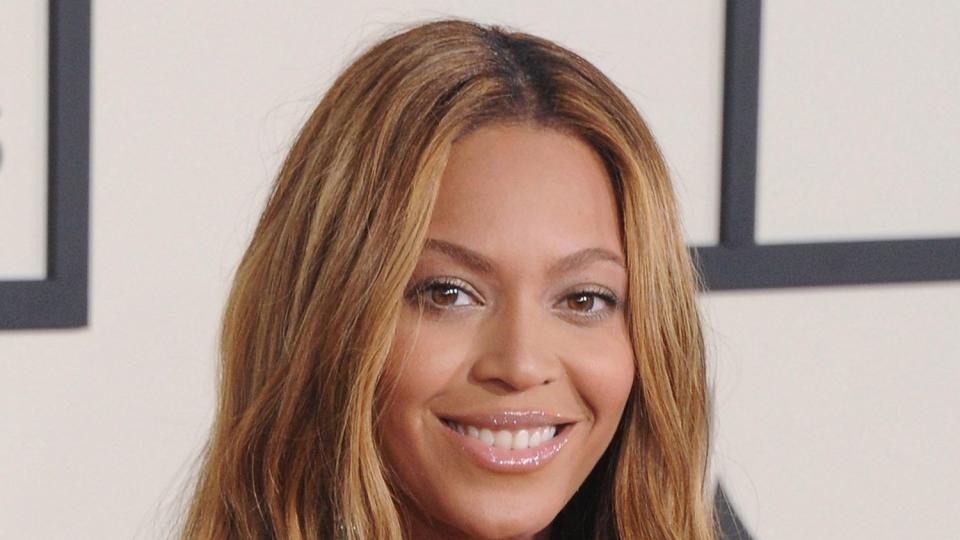 Beyonce poses on the GRAMMY Awards red carpet with caramel blonde hair