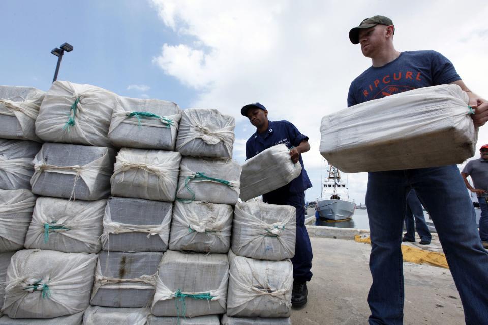 U.S. Coast Guard officers display part of the 1280 kg (2822 pounds) of cocaine, which is worth an estimated $37 million, seized in a routine patrol during a media presentation in San Juan, May 6, 2014. The Coast Guard recovered the drugs on April 29 during an at-sea interdiction south of Puerto Rico and also arrested two traffickers from the Dominican Republic. REUTERS/Ana Martinez (PUERTO RICO - Tags: CRIME LAW DRUGS SOCIETY)