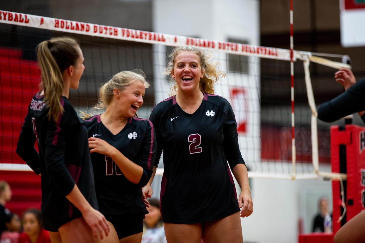 The Holland Christian varsity volleyball team celebrate a point scored against Holland Wednesday, Aug. 24, 2022, at Holland High School. 