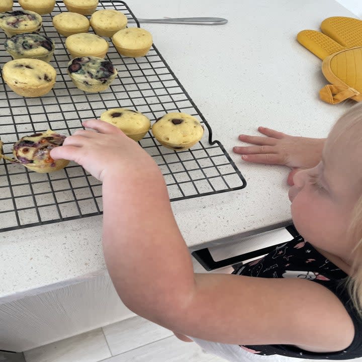 Author's daughter grabbing a mini muffin