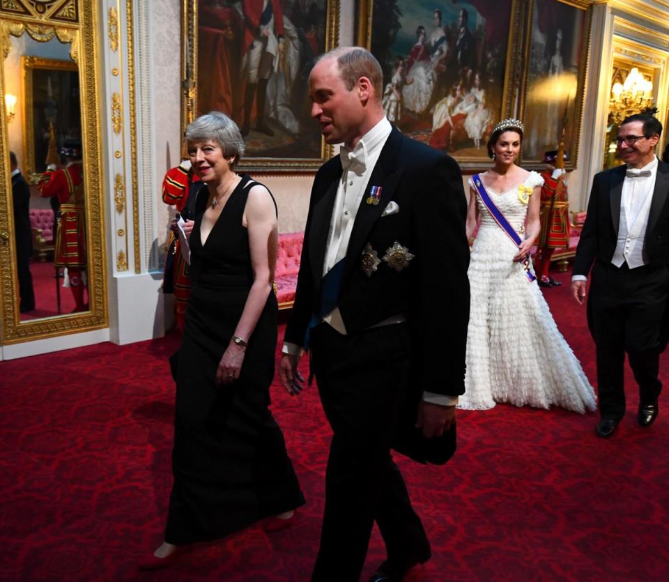 Prime Minister Theresa May and the Duke of Cambridge, followed by the Duchess of Cambridge and United States Secretary of the Treasury, Steven Mnuchin, as they arrive through the East Gallery during the State Banquet at Buckingham Palace (PA)