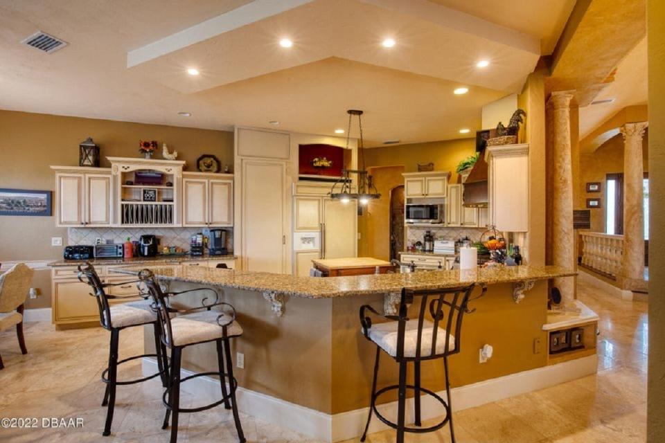 In addition to a breakfast bar that's big enough for everyone to pull up a seat, this gorgeous open kitchen also has appliances that appear to be part of the custom cabinetry.