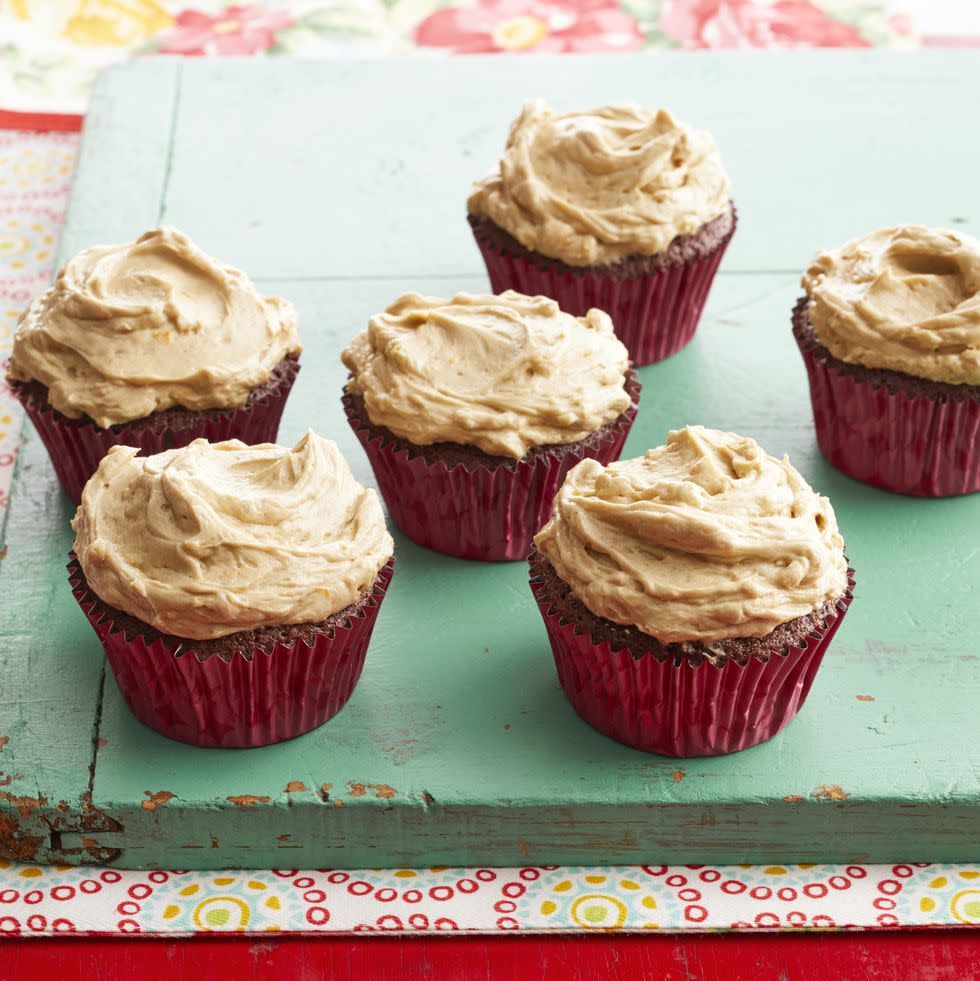 dr pepper cupcakes in red wrappers on green board