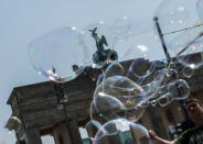 <p>Bubbles blown by a Polish street artist float near the Brandenburg Gate in Berlin on May 23, 2016. (Paul Zinken/EPA) </p>