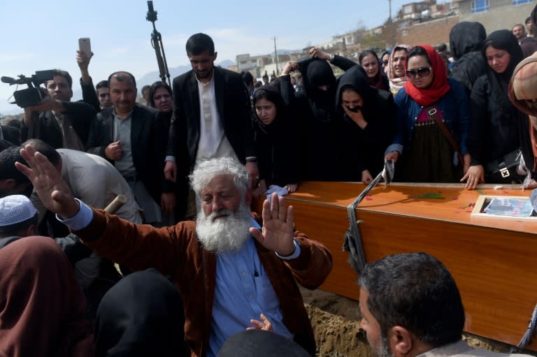 Independent Afghan civil society activist women and Afghan men lower the coffin of Afghan woman Farkhunda, 27, who was lynched by an angry mob, at the cemetary in central Kabul on March 22, 2015. Hundreds of people on March 22, attended the burial of an Afghan woman who was beaten to death and set on fire by a mob for allegedly burning a copy of the Koran. The body of Farkhunda, 27, who was lynched on March 19 by an angry mob in central Kabul, was carried to the graveyard by women amid crowds of men, an AFP reporter said, a rare act of protest in a male-dominated society. AFP PHOTO / Wakil Kohsar