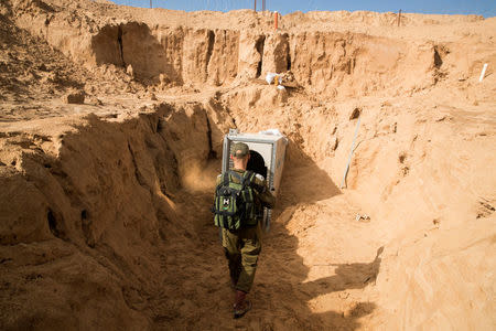 An Israeli soldier stands next to an entrance to what the Israeli military say is a cross-border attack tunnel dug from Gaza to Israel, on the Israeli side of the Gaza Strip border near Kissufim January 18, 2018. REUTERS/Jack Guez/Pool