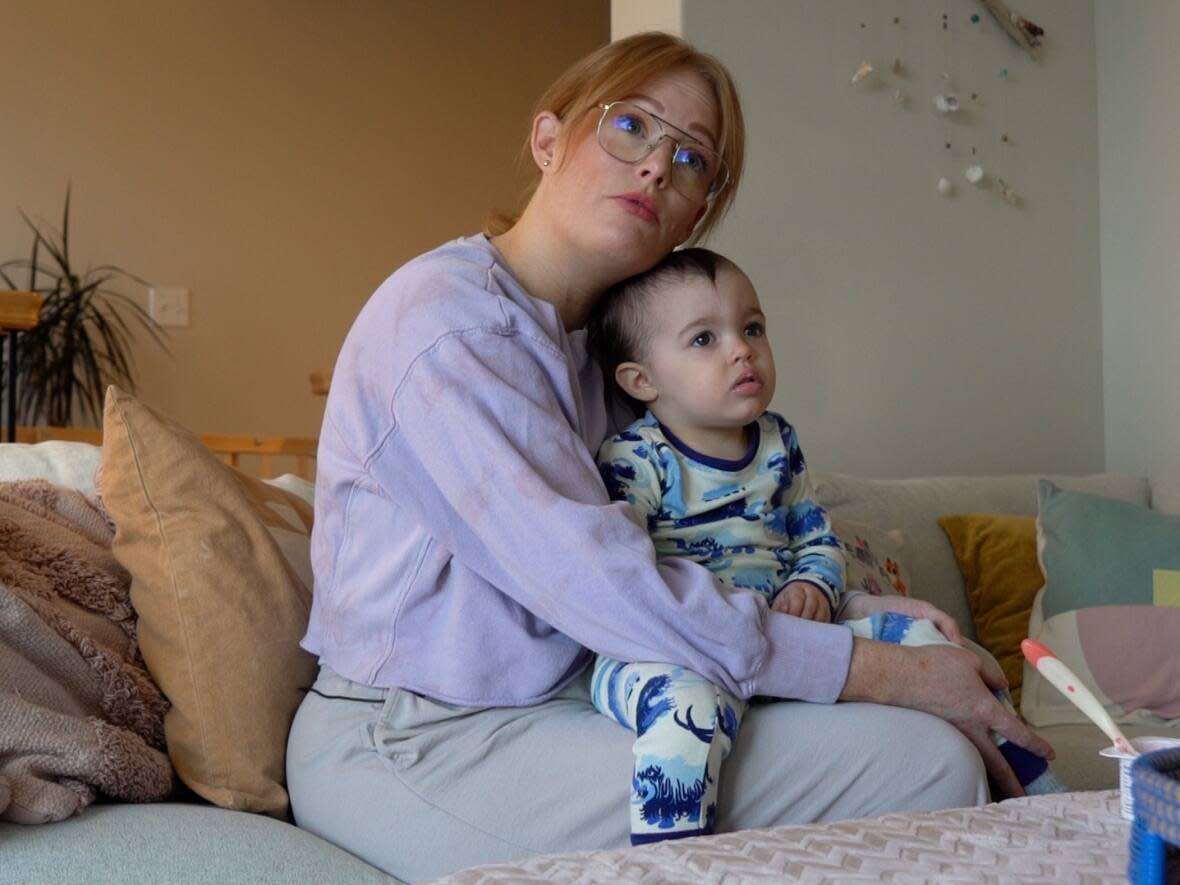 Victoria Holmes holds her two year old daughter, Franzi, at her house in Petty Harbour-Maddox Cove. (Garrett Barry/CBC - image credit)