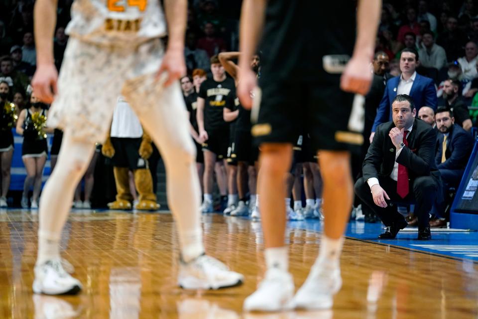 Bryant coach Jared Grasso, right, kneels during the final minute of a First Four game against Wright State in the NCAA Tournament last March. It was the school's first tournament appearance in Division I. The Bulldogs open this season on Nov. 7 against Thomas College of Maine.