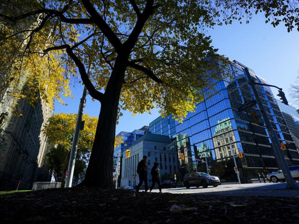  People make their way past the The Bank of Canada as they travel along Wellington Street in Ottawa.