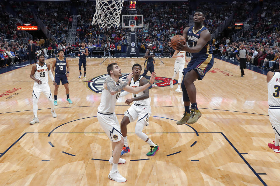 New Orleans Pelicans forward Zion Williamson (1) goes to the basket over Denver Nuggets forward Juan Hernangomez, left, and forward Jarred Vanderbilt in the first half of an NBA basketball game in New Orleans, Friday, Jan. 24, 2020. (AP Photo/Gerald Herbert)